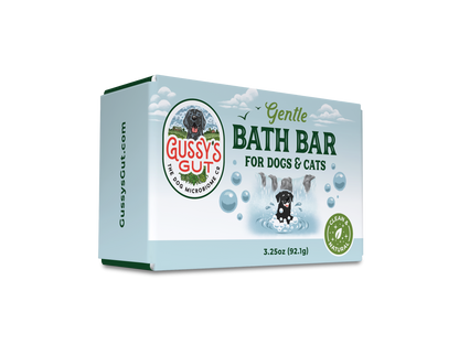 Eco-friendly dog and cat bath bar in light blue packaging with a playful black dog image, green accents, and "Gussy’s Gut"...