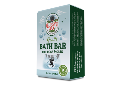 Organic dog and cat bath bar in light blue packaging with a black dog illustration, bubbles, and green accents, supporting...