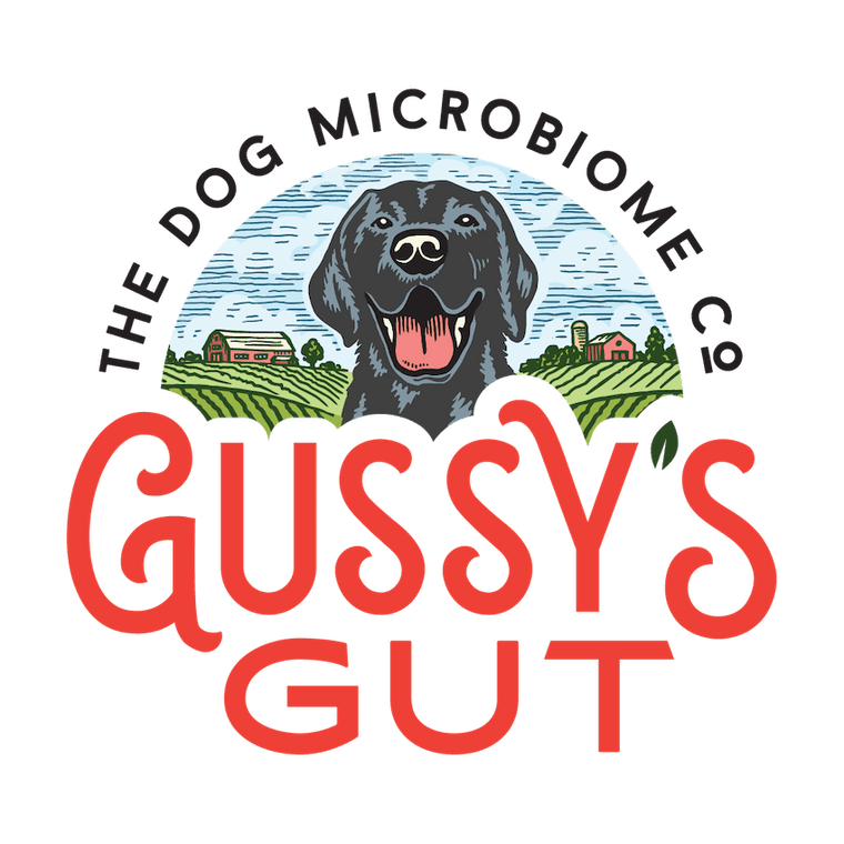 Logo featuring a black dog with open mouth, surrounded by farm fields and buildings, with "Gussy’s Gut" in bold red letters.