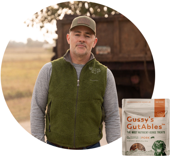 Man in gray long-sleeve shirt and green fleece vest, outdoors; product image of Gussy’s GutAbles pork treats for dog gut h...